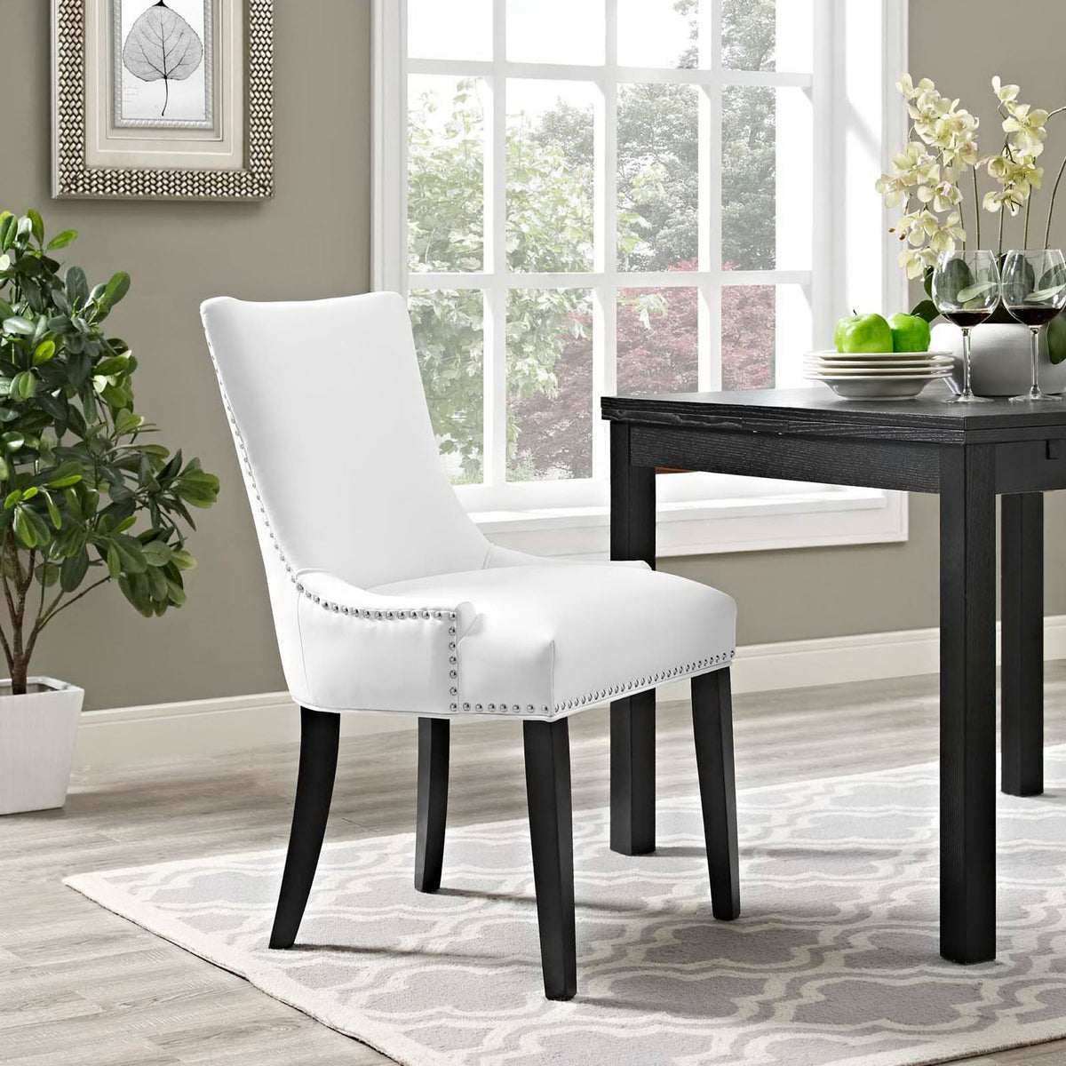 White vegan leather dining chair adding modern elegance beside a dark wood table in a bright dining room || EEI-2228-WHI || front_angle_room