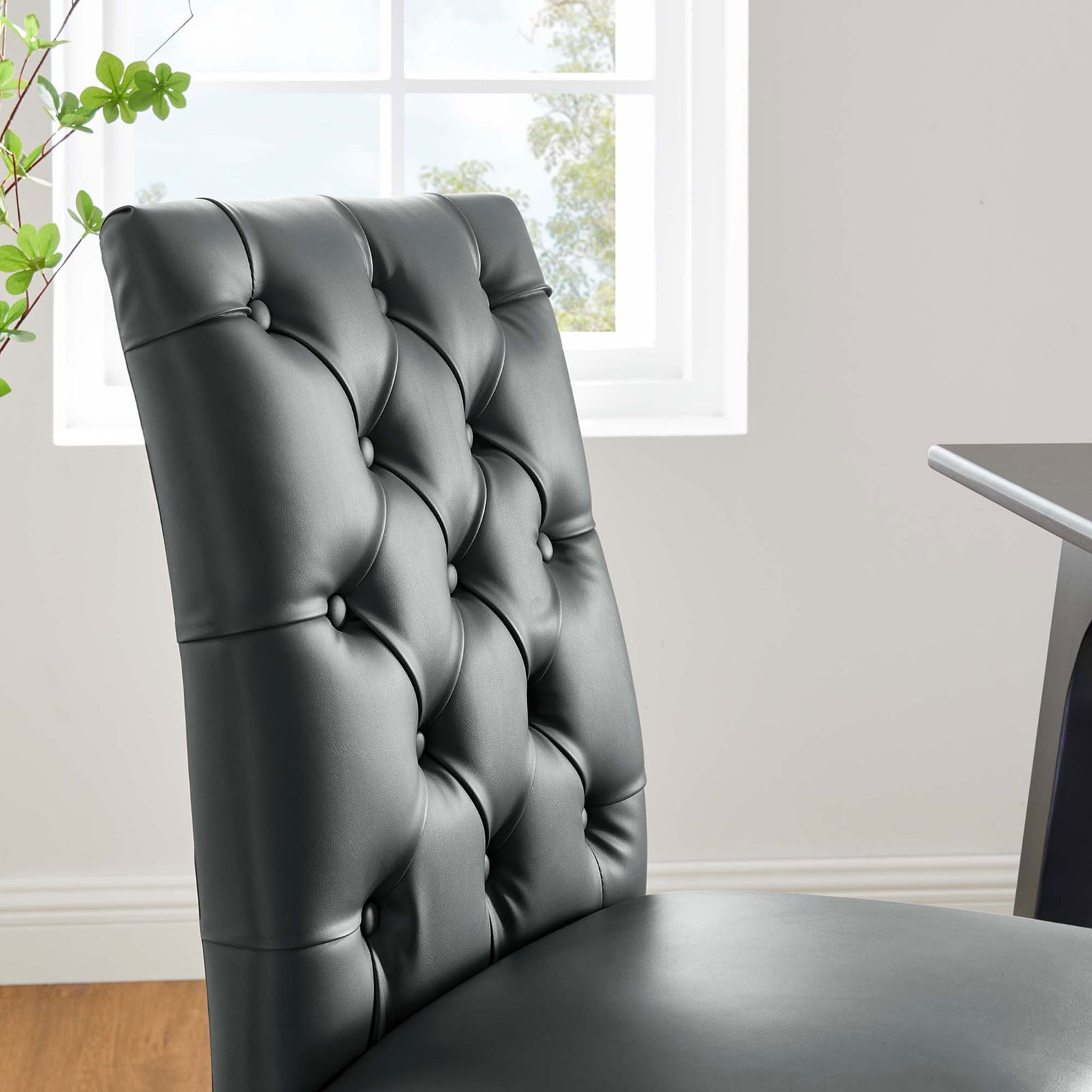 Duchess gray tufted dining chair beside a bright window for an inviting modern dining space || EEI-2230-GRY || detail_room