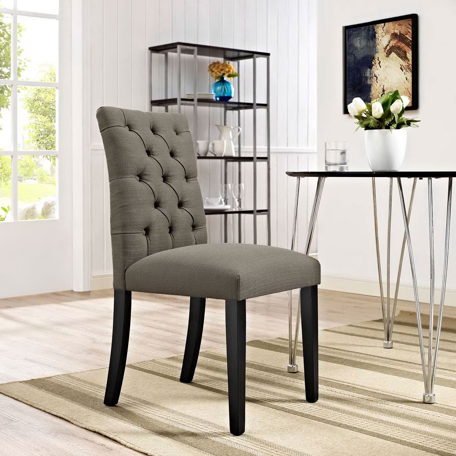 Tufted granite dining chair styled in a bright modern dining room with metal table and decor accents || EEI-2231-GRA || front_angle_room