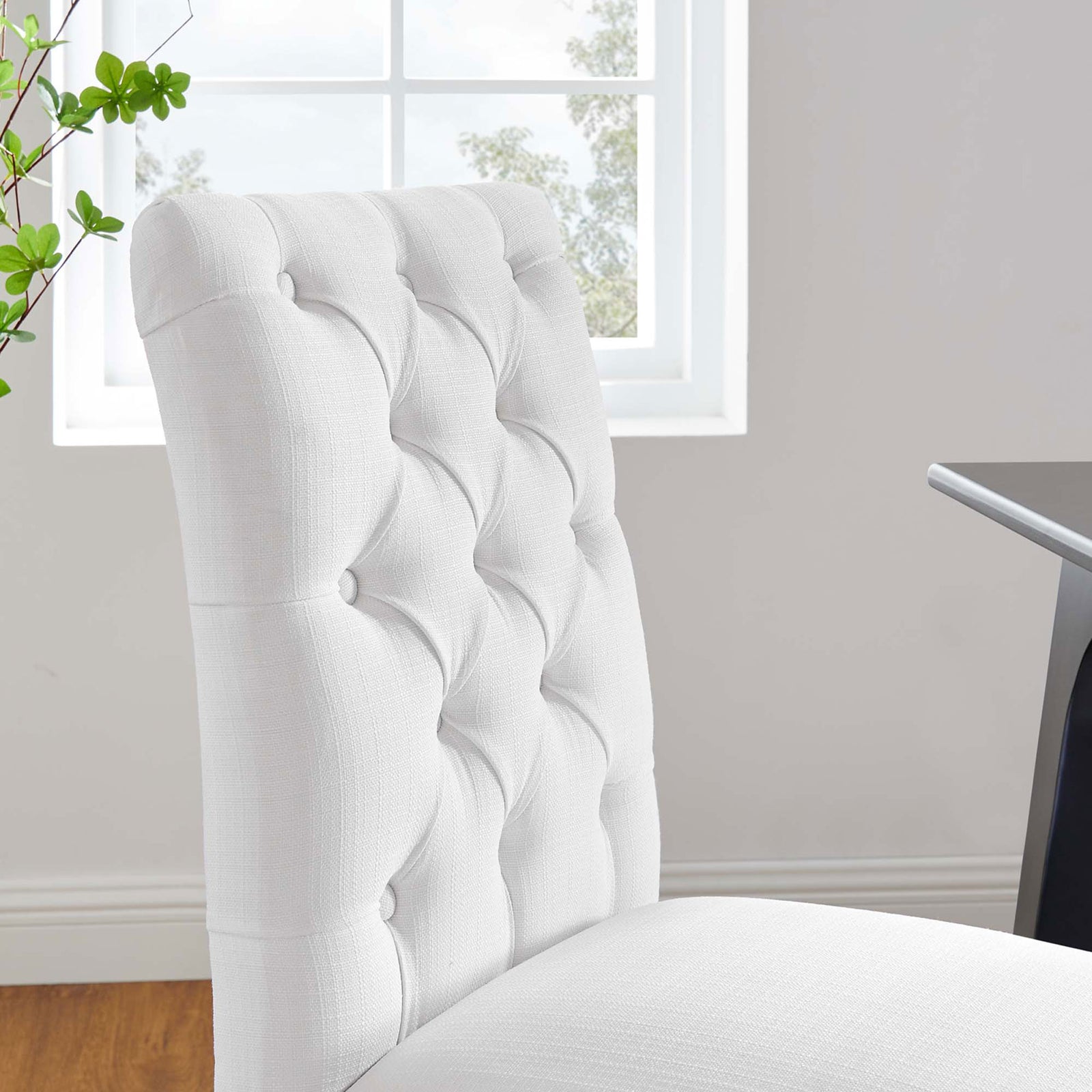 White tufted dining chair back styled beside a window with greenery in a modern dining space || EEI-2231-WHI || detail_room