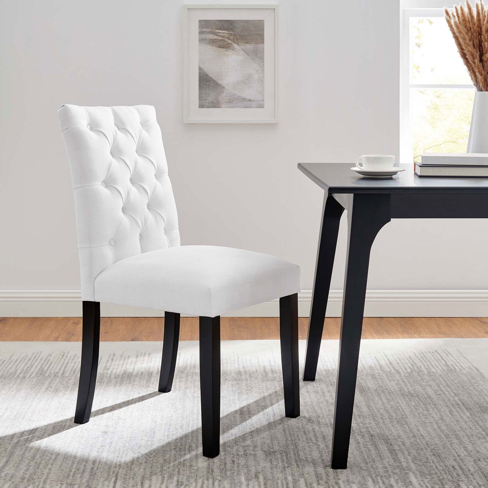 White tufted dining chair paired with a black dining table in a bright modern dining room || EEI-2231-WHI || front_angle_room