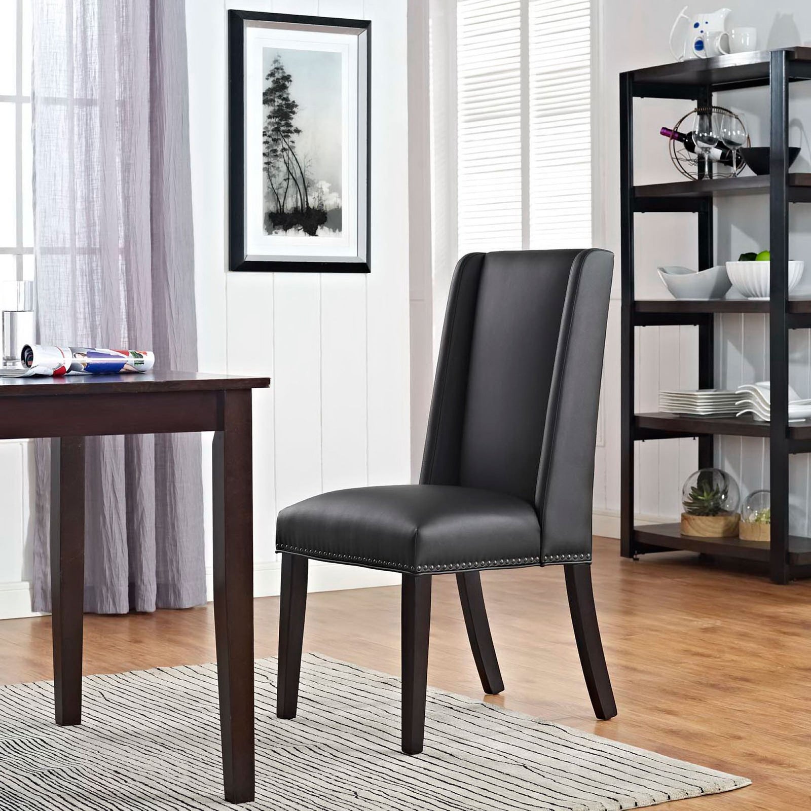 Black vegan leather dining chair styled in a modern dining room with wood table and shelving || EEI-2232-BLK || front_angle_room