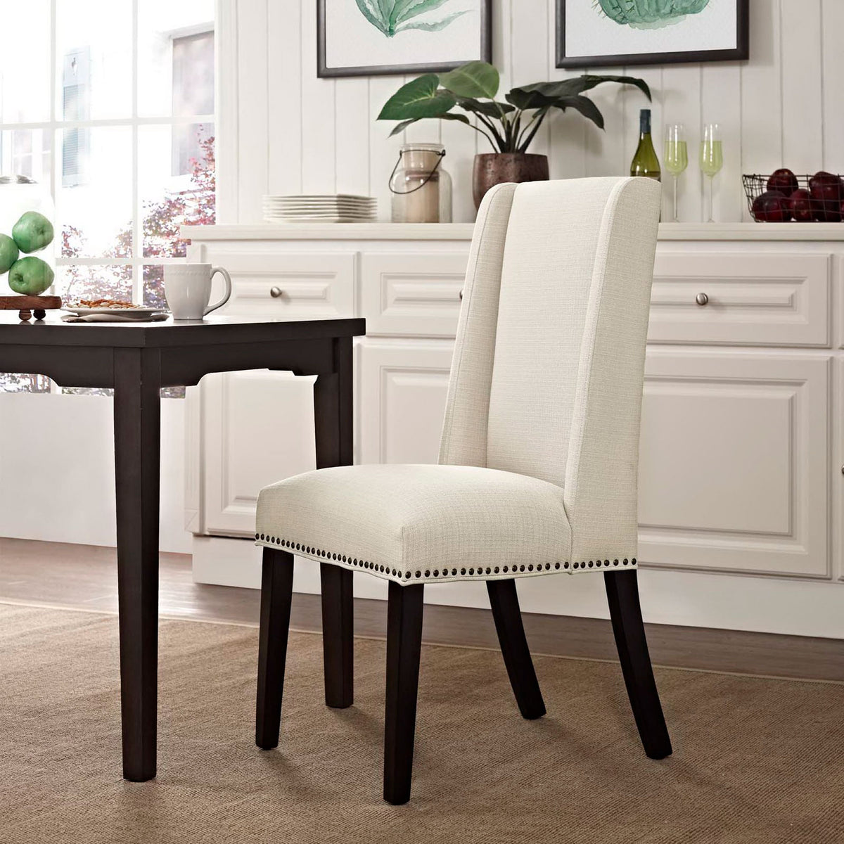 Beige fabric dining chair placed at a dark wood table in a bright, inviting dining room. || EEI-2233-BEI || front_angle_room