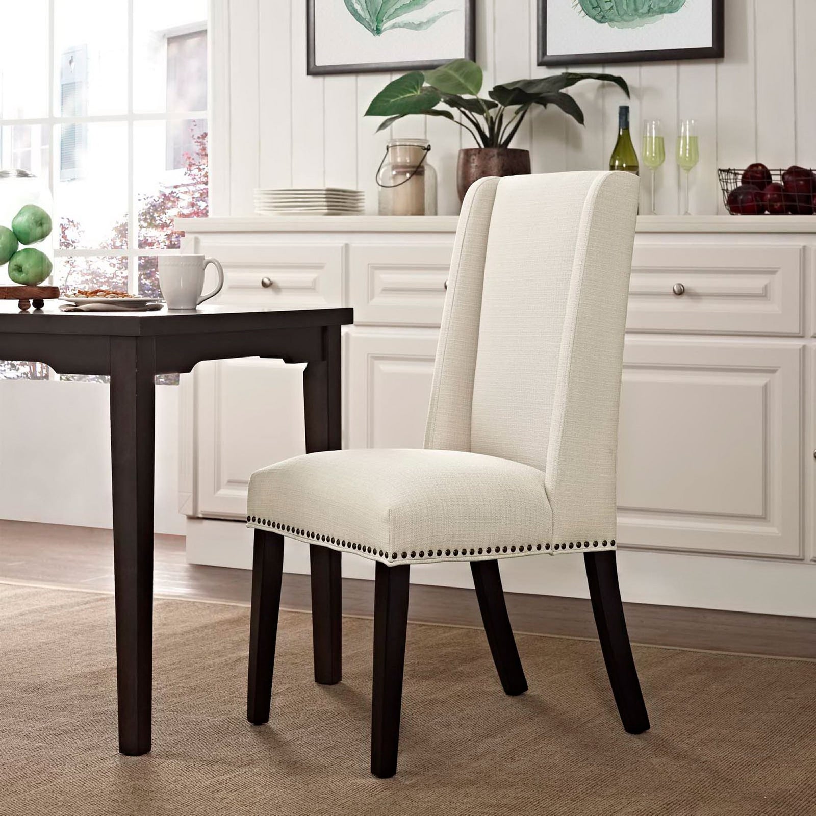 Beige fabric dining chair placed at a dark wood table in a bright, inviting dining room. || EEI-2233-BEI || front_angle_room