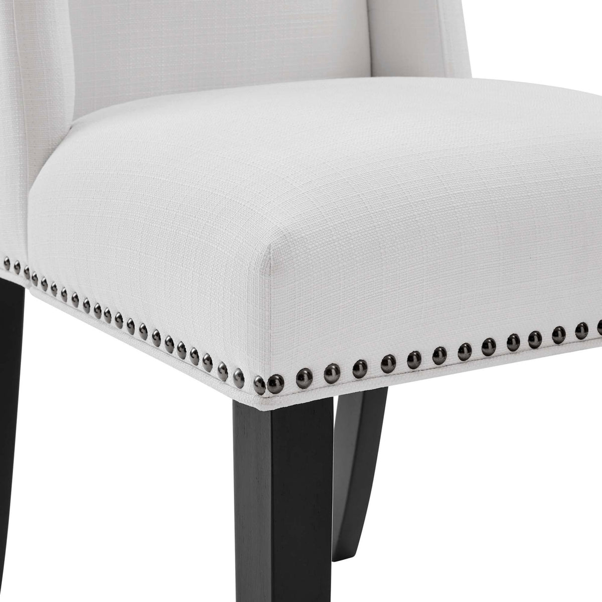 Seat of white dining chair featuring textured fabric, nailhead border, and dark wood leg || EEI-2233-WHI || detail_studio