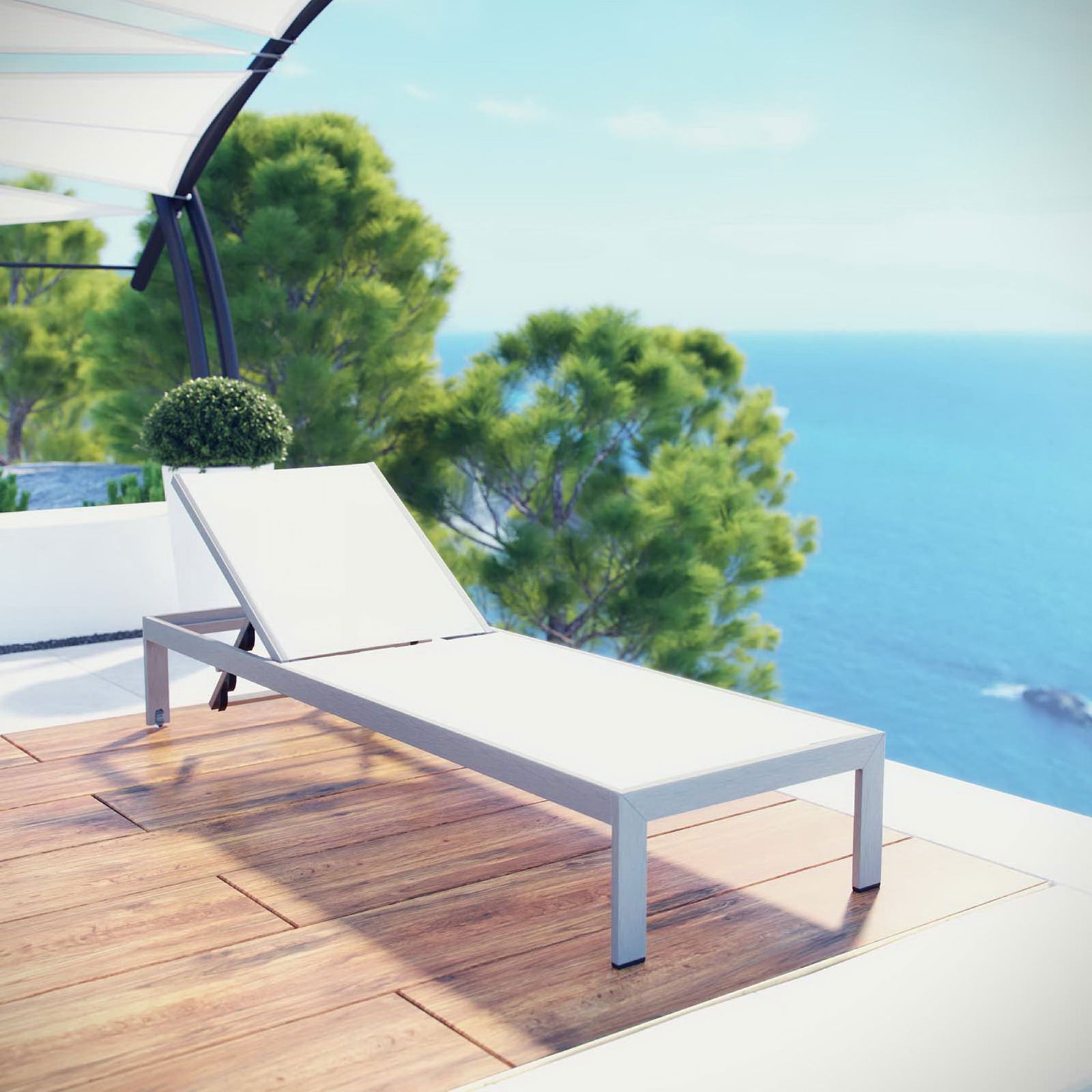 White mesh Shore chaise on a sunlit terrace overlooking the sea || EEI-2249-SLV-WHI || front_angle_room