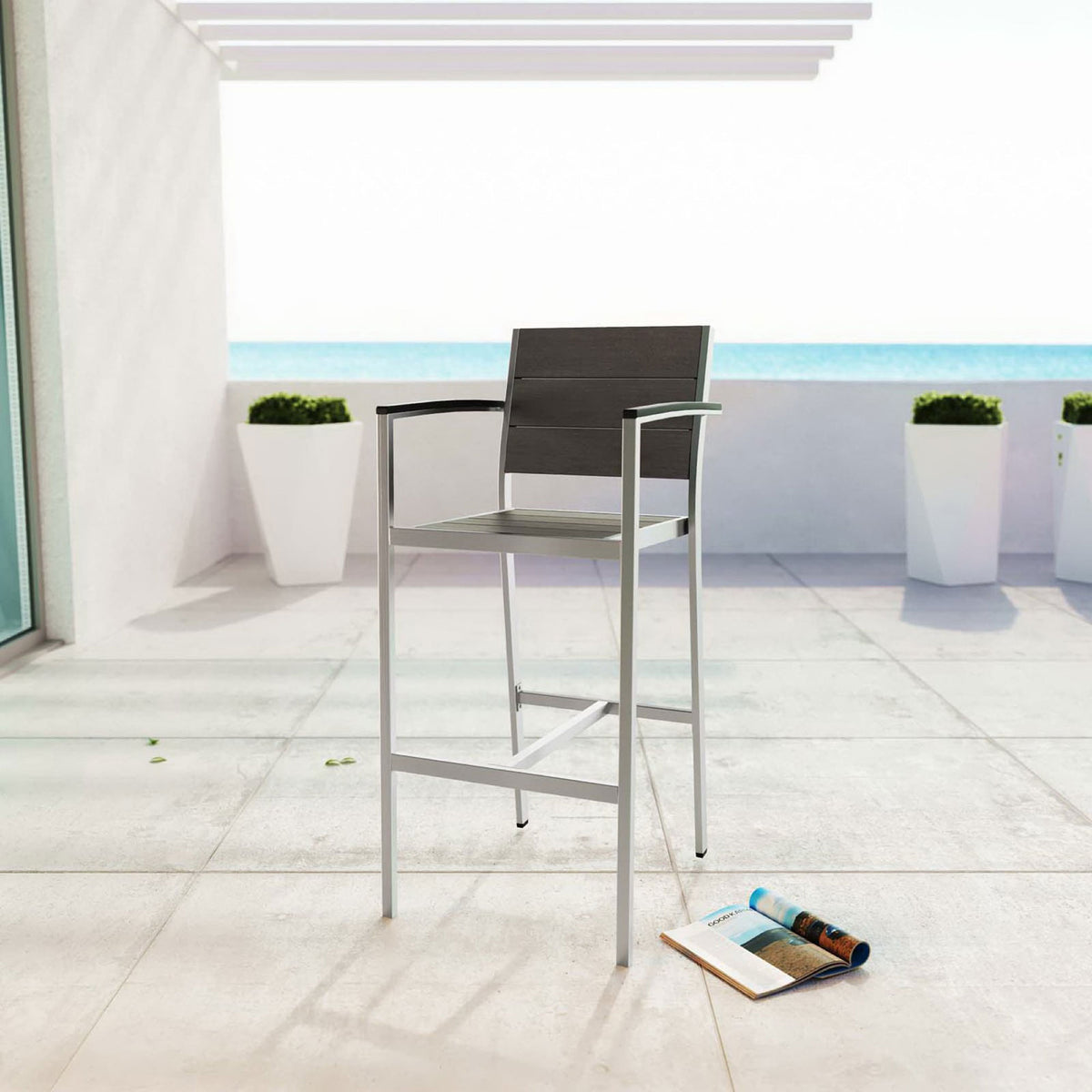 Armrest bar stool styled on a bright oceanview terrace to complement modern outdoor lounge spaces || EEI-2254-SLV-GRY || front_angle_room