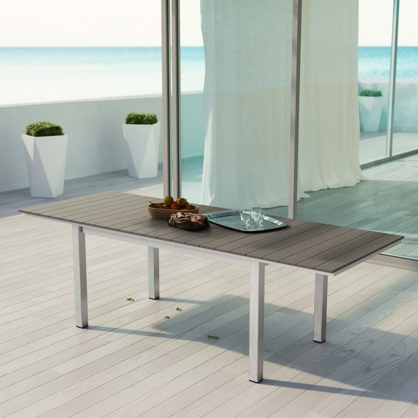 Extendable Shore patio table styled with snacks and drinks on a sunlit deck overlooking the water || EEI-2257-SLV-GRY || front_angle_converted_room