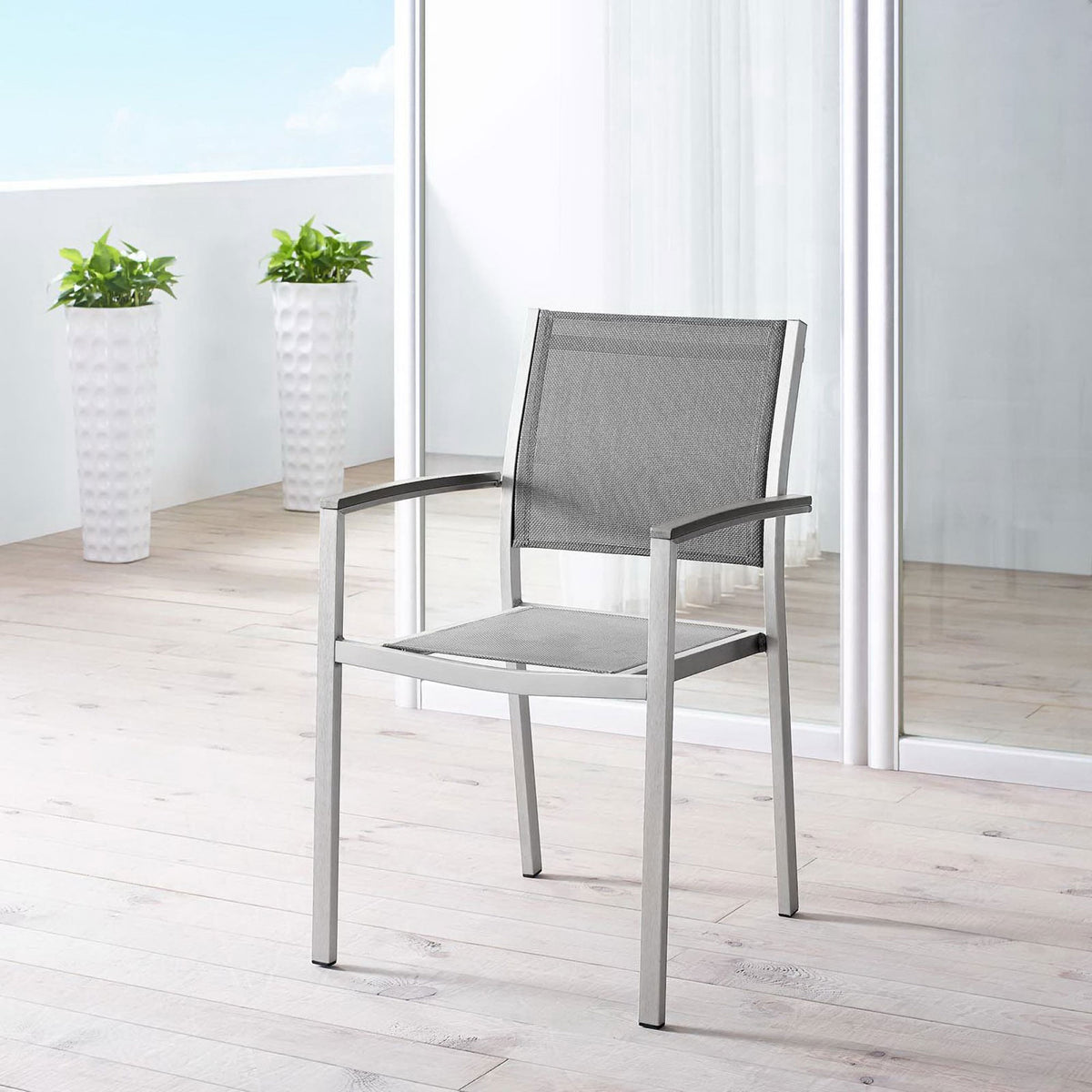 Gray mesh Shore armchair brings sleek style to a bright balcony-style patio space. || EEI-2272-SLV-GRY || front_angle_room