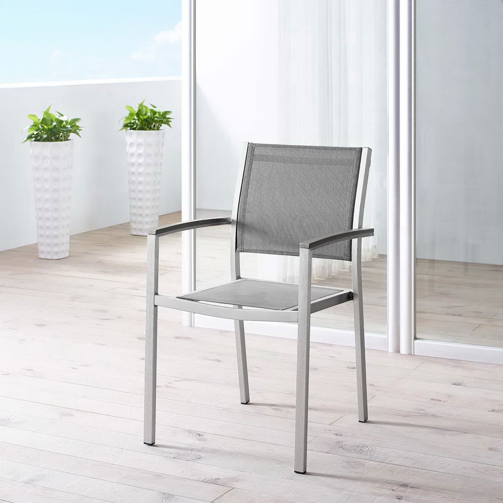 Gray mesh Shore armchair brings sleek style to a bright balcony-style patio space. || EEI-2272-SLV-GRY || front_angle_room
