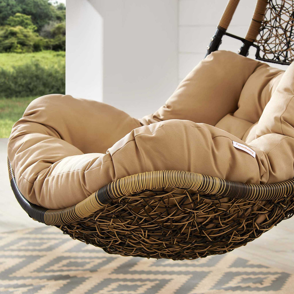 Plush mocha cushion and woven brown rattan seat adding resort style comfort to your space.