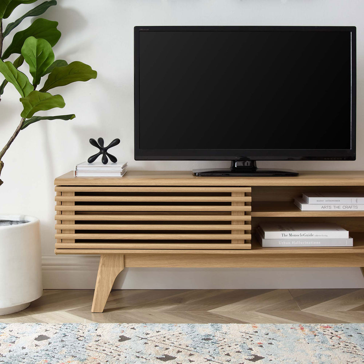 Oak TV stand styled in a modern living room with TV, decor accents, and a soft textured area rug || EEI-2539-OAK || front_room