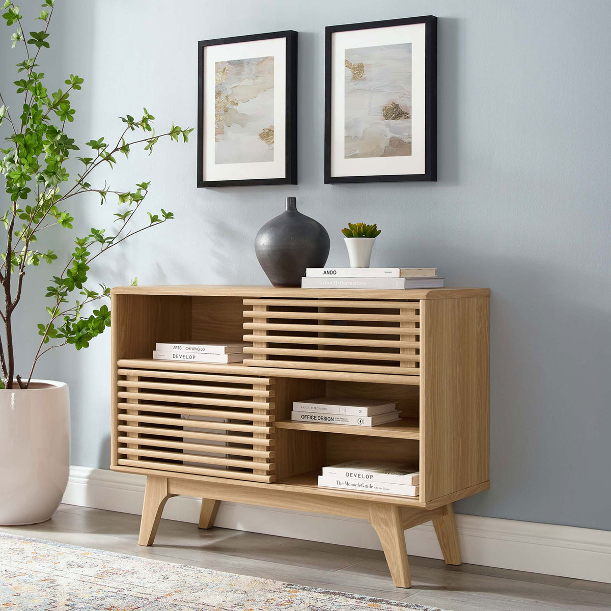 Render oak display stand used as a media console with stacked books and decorative vase || EEI-2542-OAK || front_angle_room