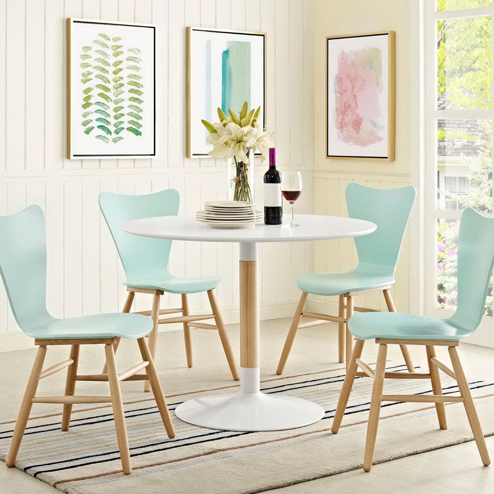 Round white dining table styled in a bright modern dining room with pastel chairs and decor || EEI-2666-WHI-SET || front_angle_room