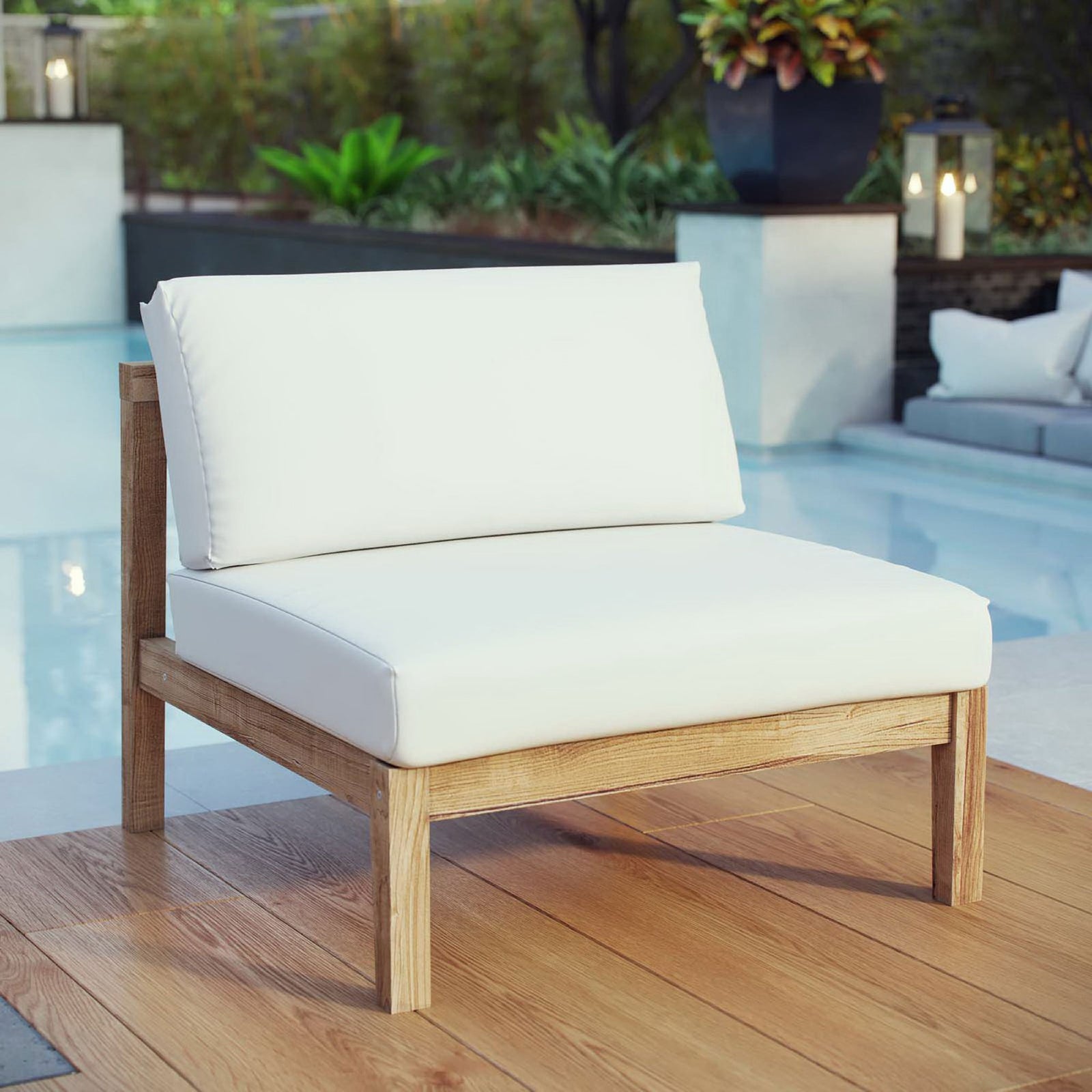 Poolside teak armless chair with generous white cushions creating a serene lounge retreat || EEI-2697-NAT-WHI || front_angle_room