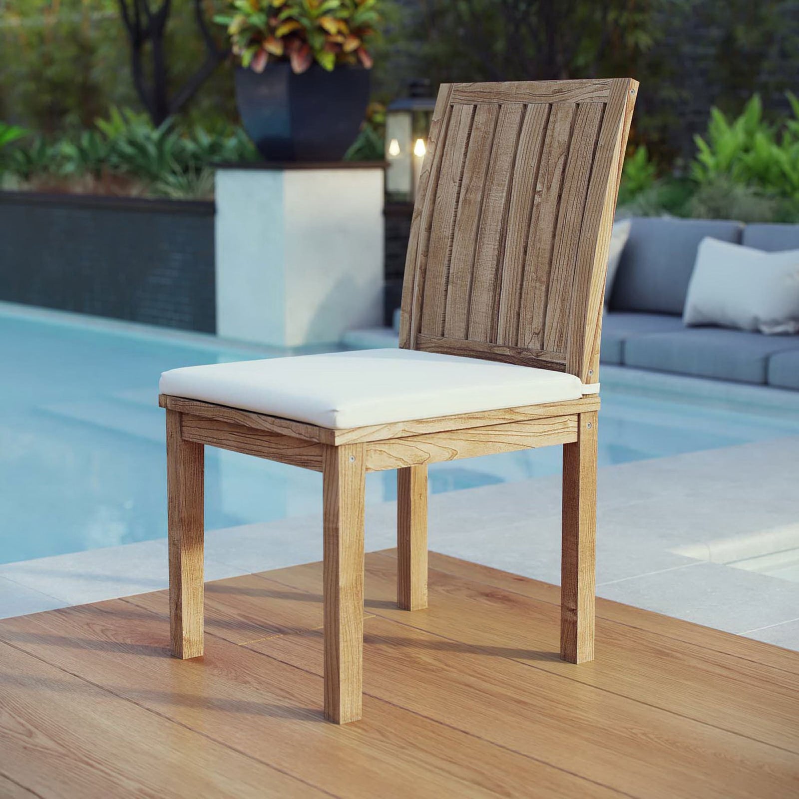 Teak side chair with white cushion arranged beside a pool for casual outdoor seating || EEI-2700-NAT-WHI || front_angle_room