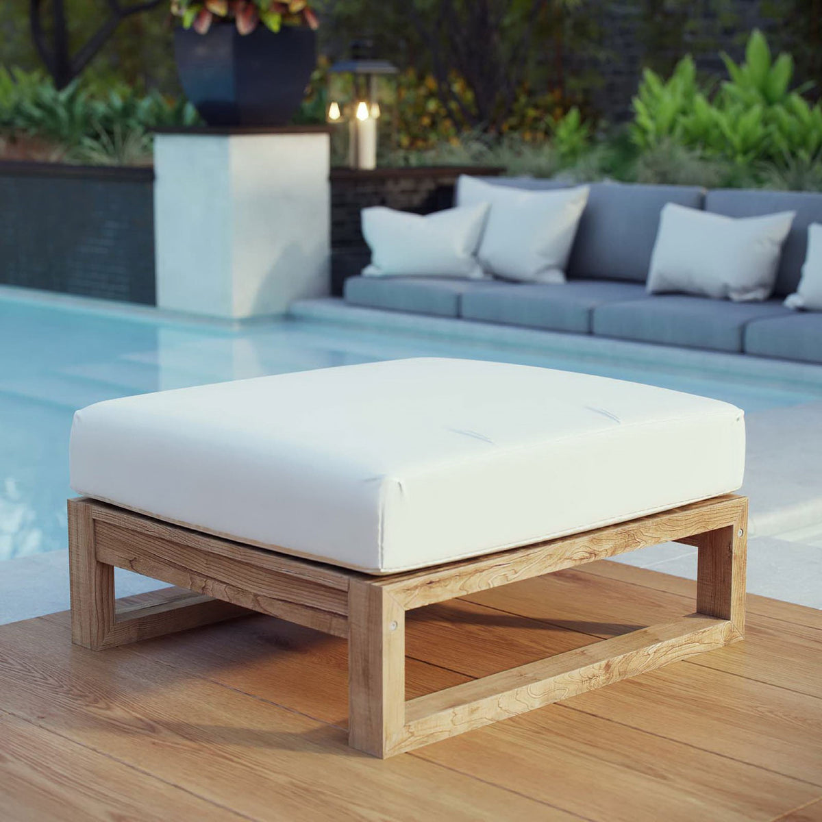 Outdoor teak ottoman with crisp white cushion styled beside a modern poolside lounge || EEI-2708-NAT-WHI || front_angle_room