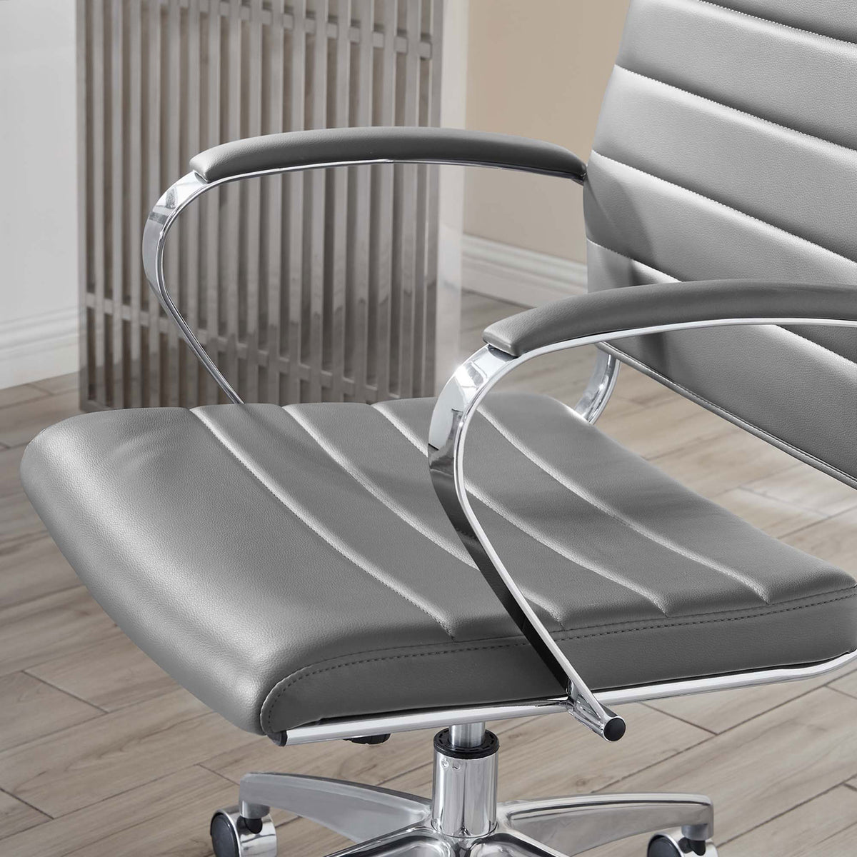 Gray ribbed seat and padded armrest of the Jive chair styled beside a modern glass desk || EEI-272-GRY || detail_room