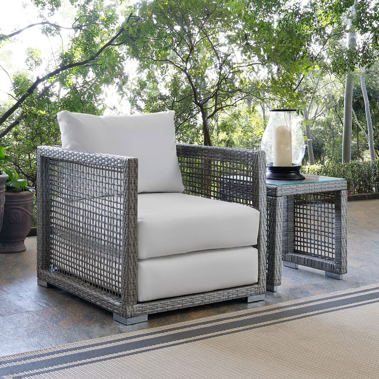 White cushion Aura armchair styled on a serene patio beside a matching woven side table || EEI-2918-GRY-WHI || front_angle_room