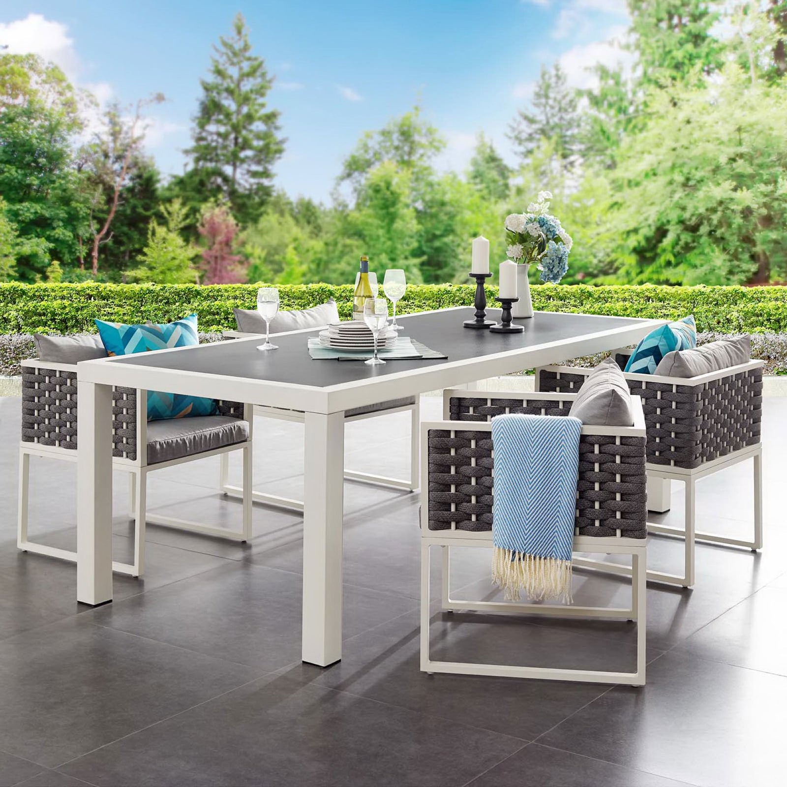 Outdoor dining table styled with coordinated chairs, pillows, and decor on a modern patio setting || EEI-3052-WHI-GRY || front_angle_room