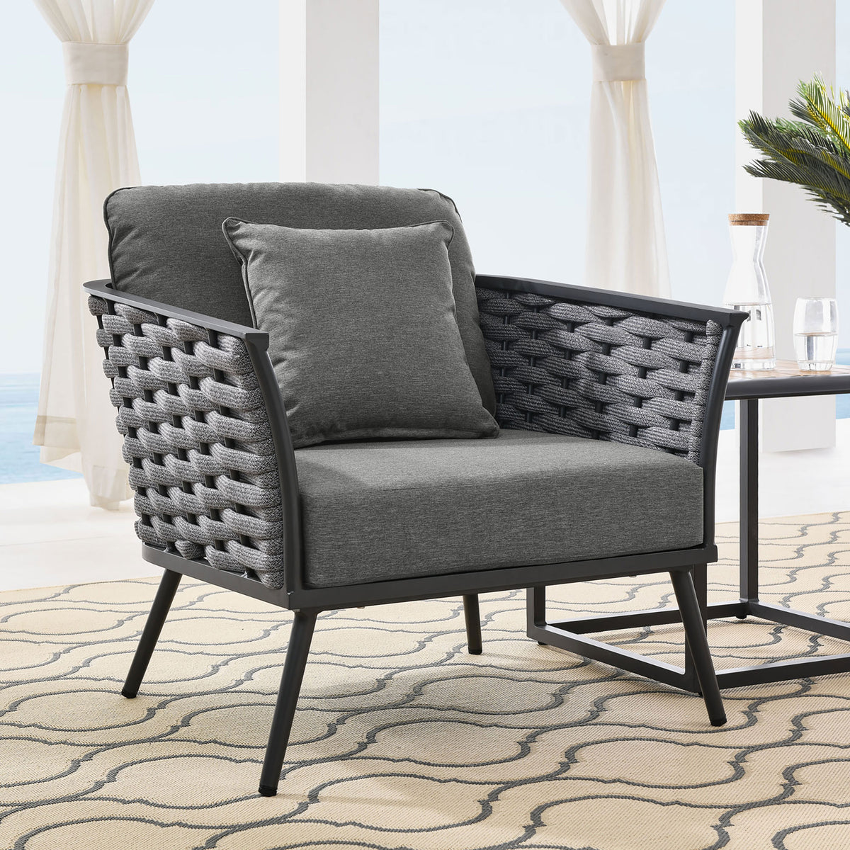 Stance gray outdoor armchair with charcoal rope sides styled beside a patio drink table || EEI-3054-GRY-CHA || front_angle_room