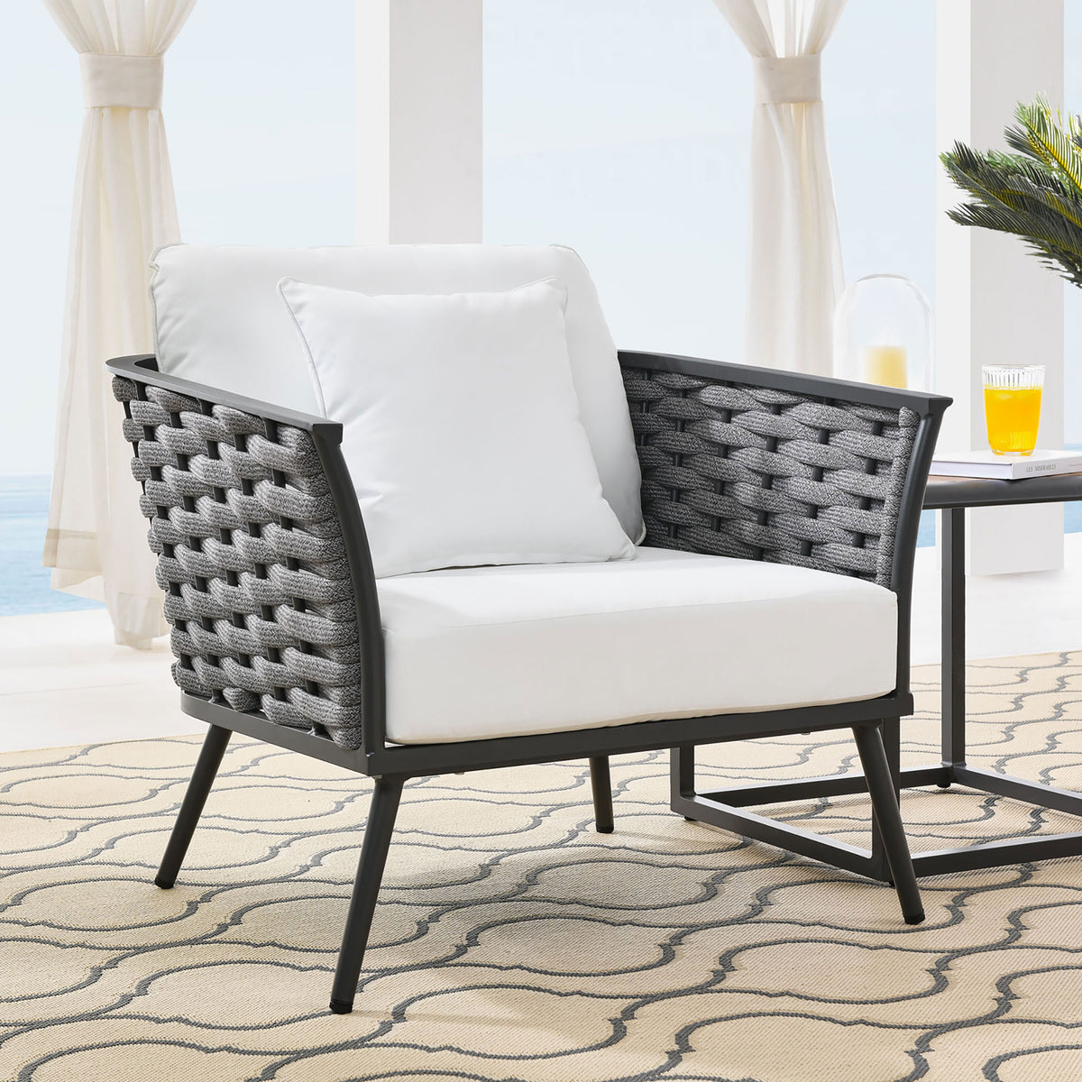 Stance outdoor armchair with white cushions and rope sides arranged beside a patio table || EEI-3054-GRY-WHI || front_angle_room