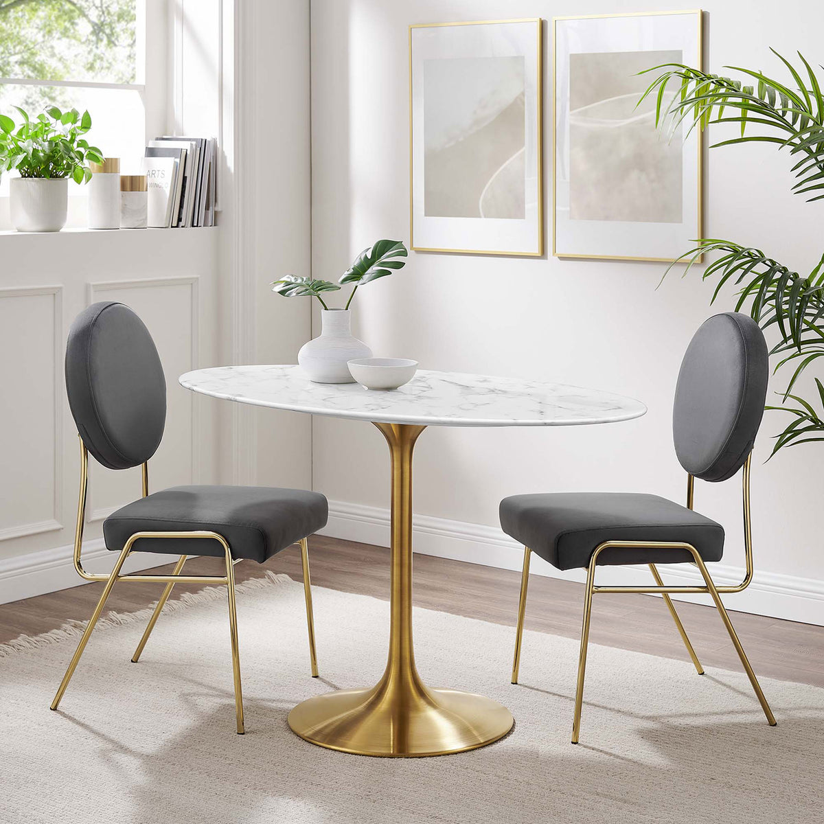 White faux marble dining table with gold pedestal base paired with gray chairs in a bright dining space || EEI-3216-GLD-WHI || front_angle_room
