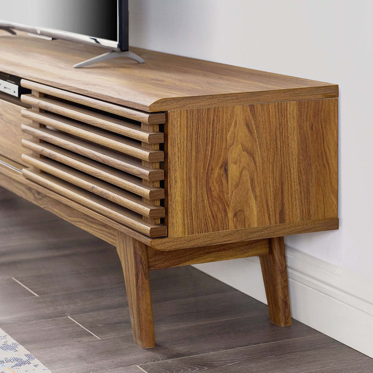 Detail of walnut TV stand corner showing slatted front and flared tapered leg