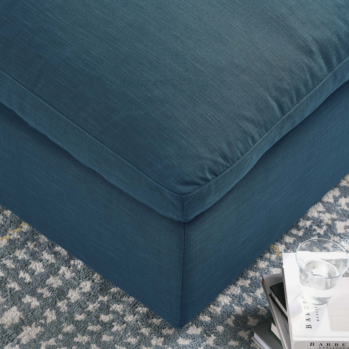 Tailored stitching traces the edge of the plush azure cushion above its upholstered base