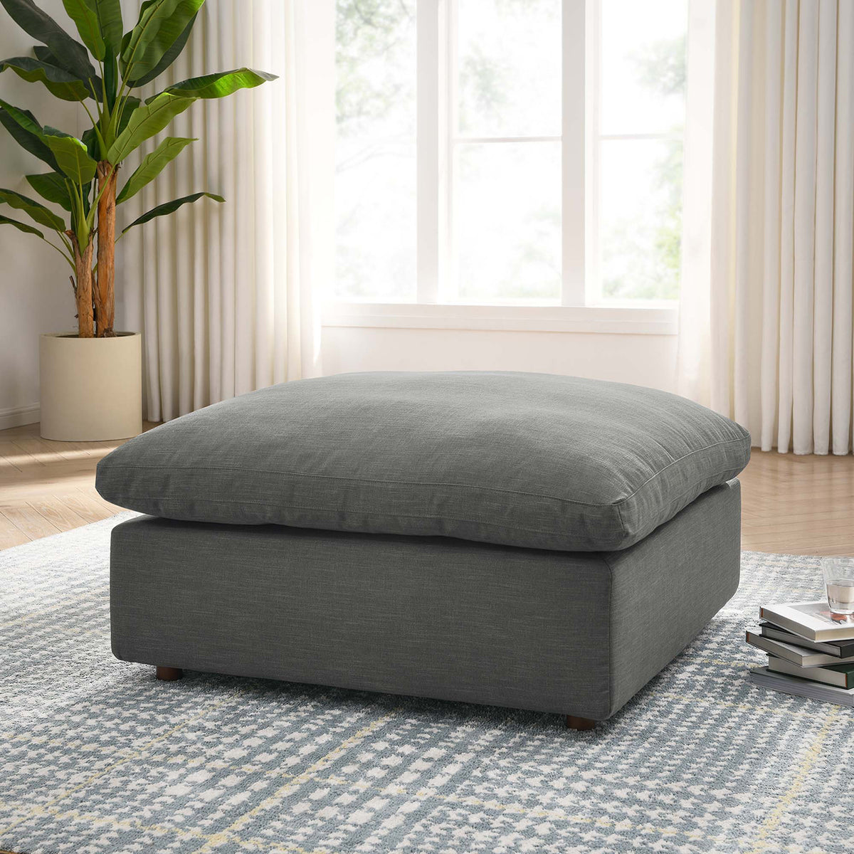 A cushy gray ottoman offers room to stretch out in a bright, relaxed living space
