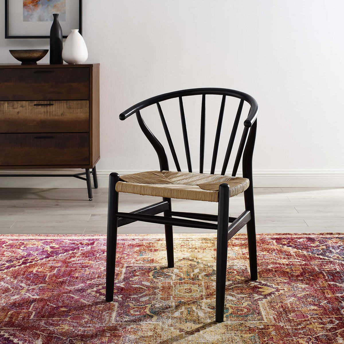 A black spindle-back chair with a natural woven seat adds texture and contrast to a cozy living space