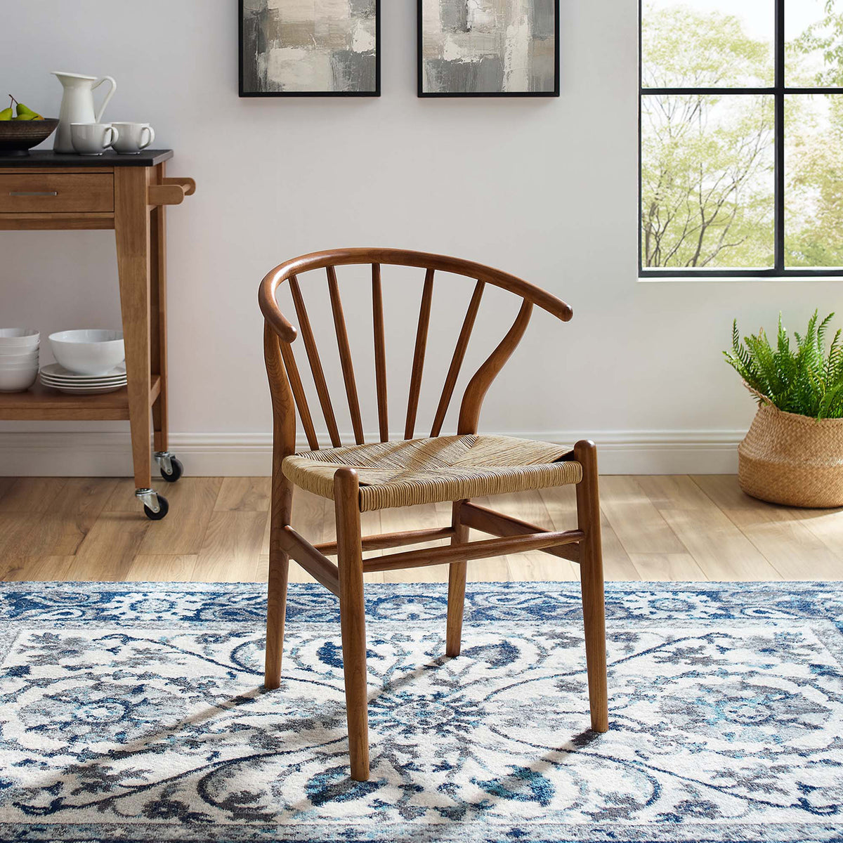 A walnut-finished spindle chair with a woven seat adds warmth and texture to a bright living space