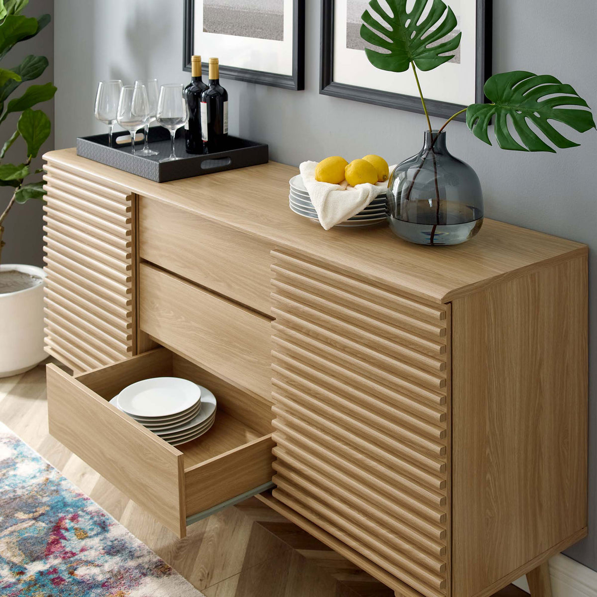 Oak buffet shows a drawer pulled out and doors shifted to display dinnerware and bar items || EEI-3344-OAK || front_angle_open_room