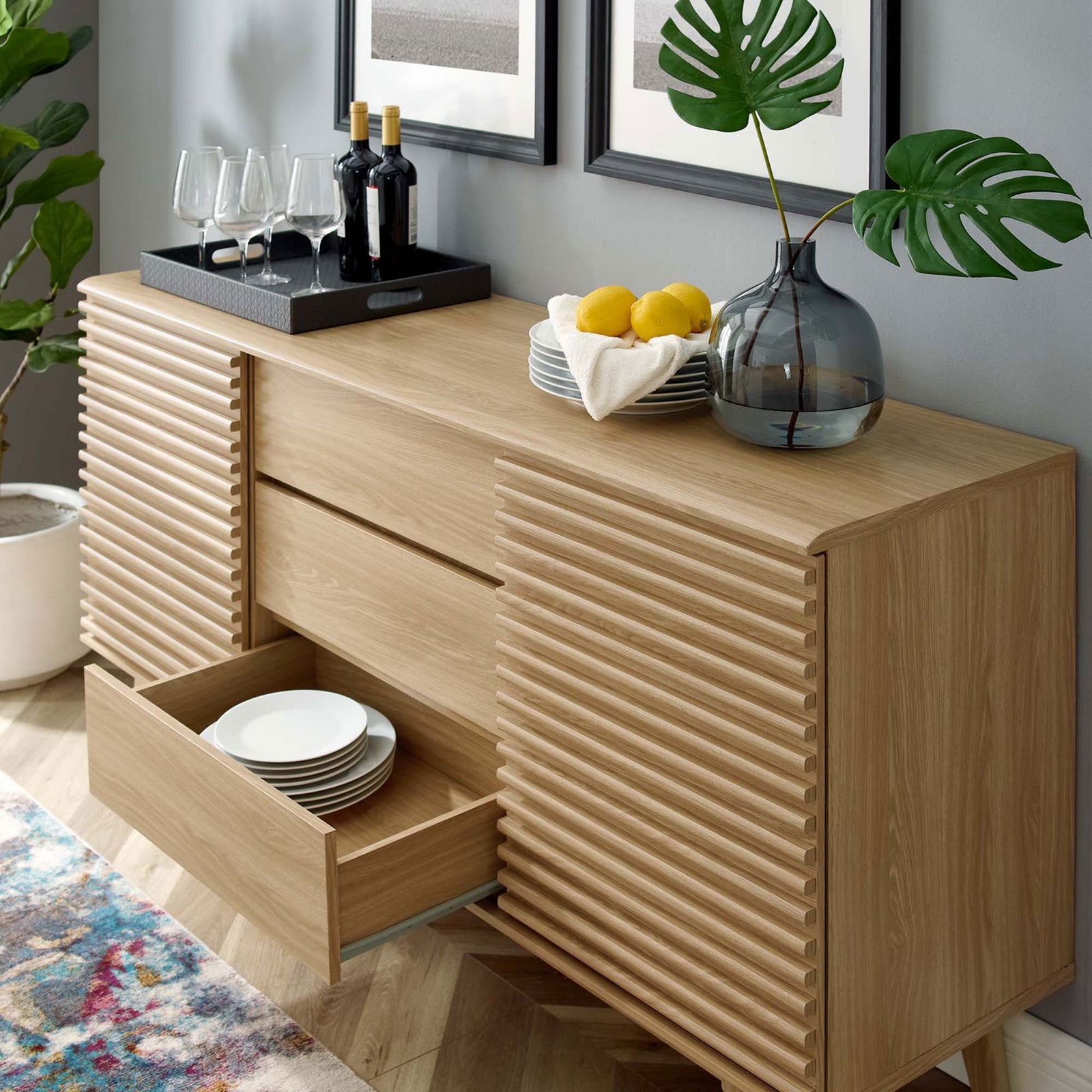 Oak buffet shows a drawer pulled out and doors shifted to display dinnerware and bar items || EEI-3344-OAK || front_angle_open_room