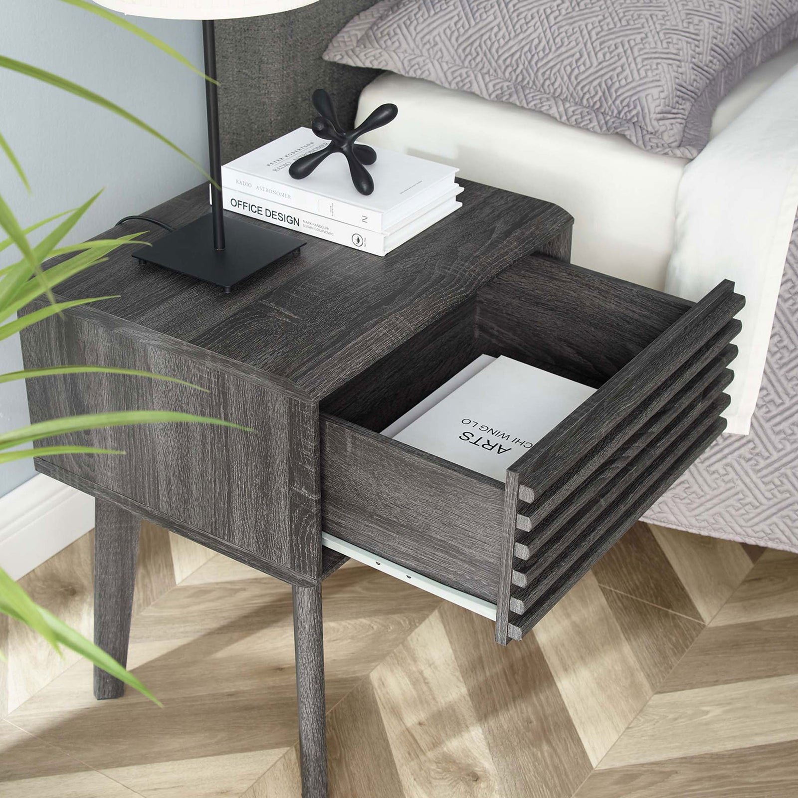 Charcoal nightstand beside bed with drawer open to reveal books and bedside essentials || EEI-3345-CHA || front_angle_open_room