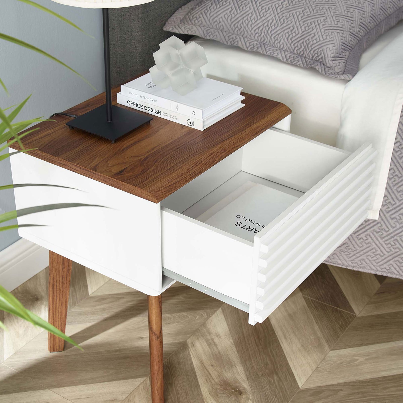 Bedside end table with lamp and books, highlighting easy-access drawer storage in a modern bedroom || EEI-3345-WAL-WHI || front_angle_open_room