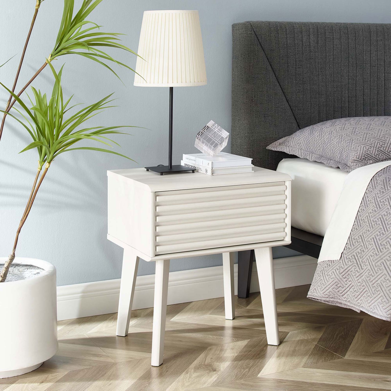 White mid-century nightstand styled beside the bed with books and decor for a clean, modern bedroom look. || EEI-3345-WHI || front_angle_room