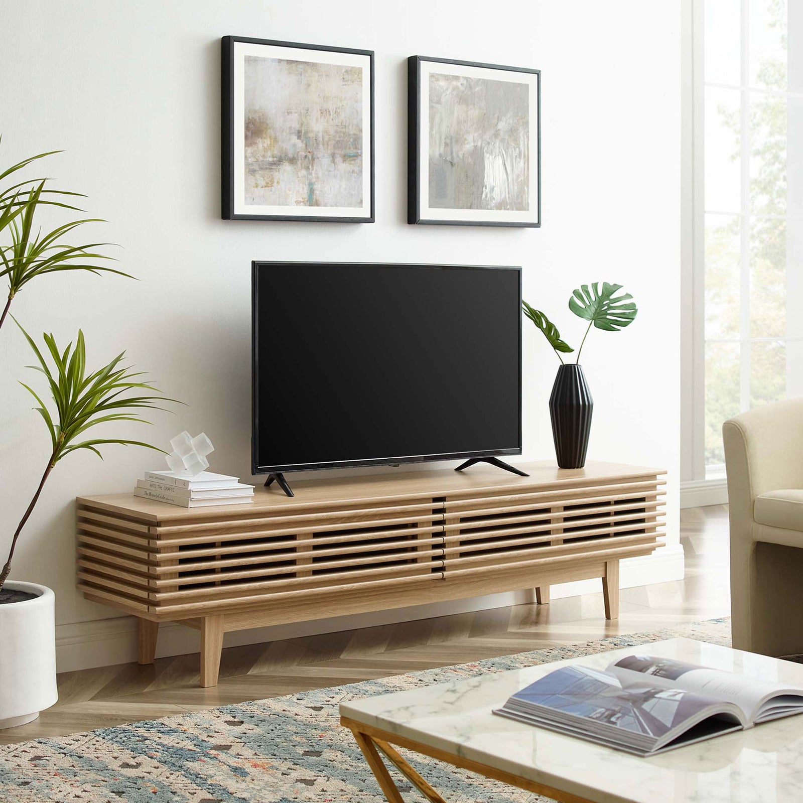 Oak TV stand styled in a modern living room with TV and decor accents. || EEI-3348-OAK || front_angle_room