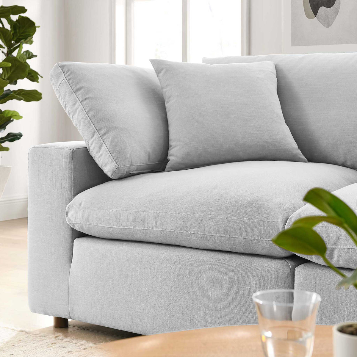 Plump light gray cushions and a broad armrest make this sofa inviting