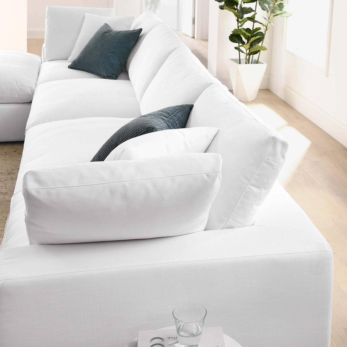 A line of plump white back cushions adds soft support above the sectional's deep seats.