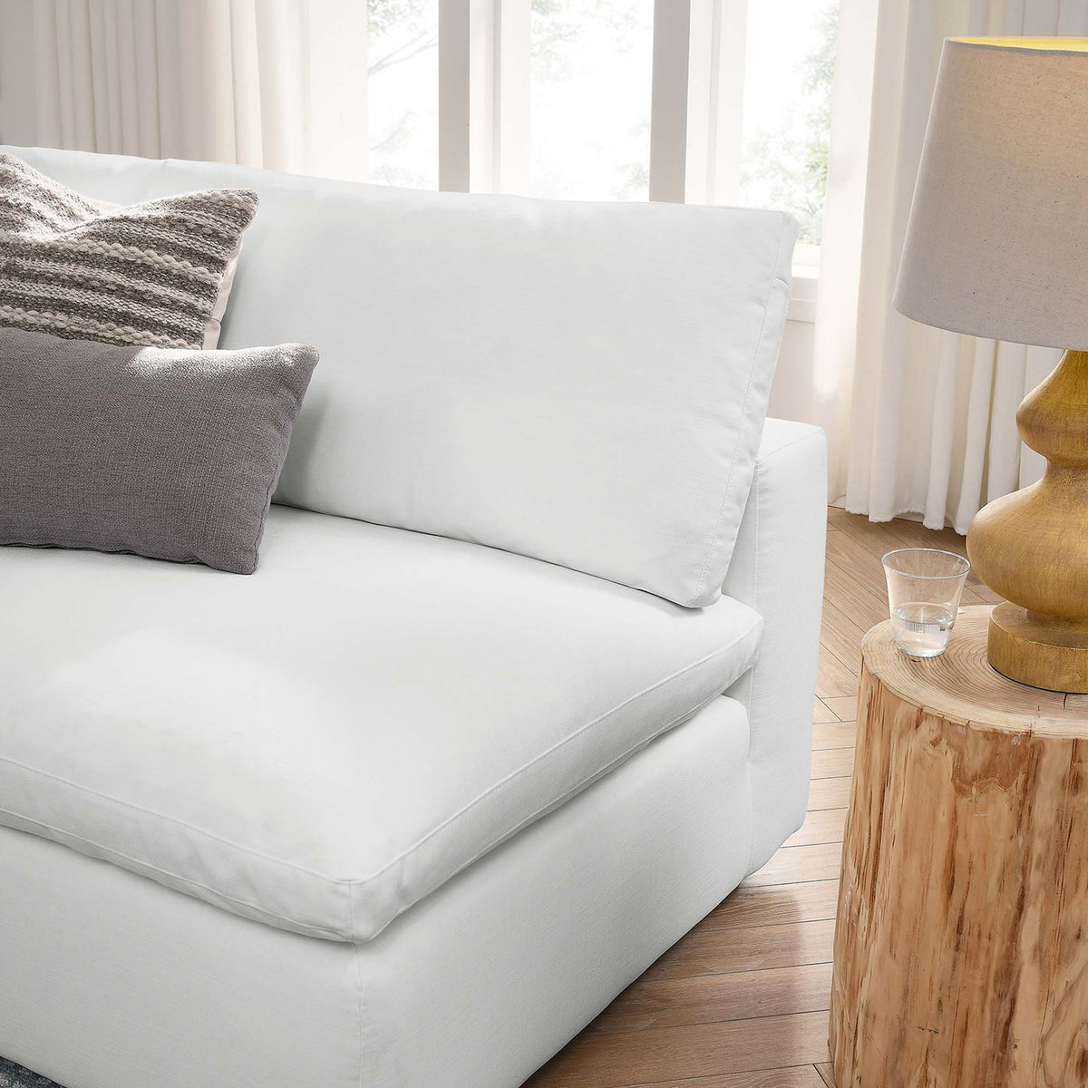 A plump white back pillow and broad seat cushion soften the sectional's open end.