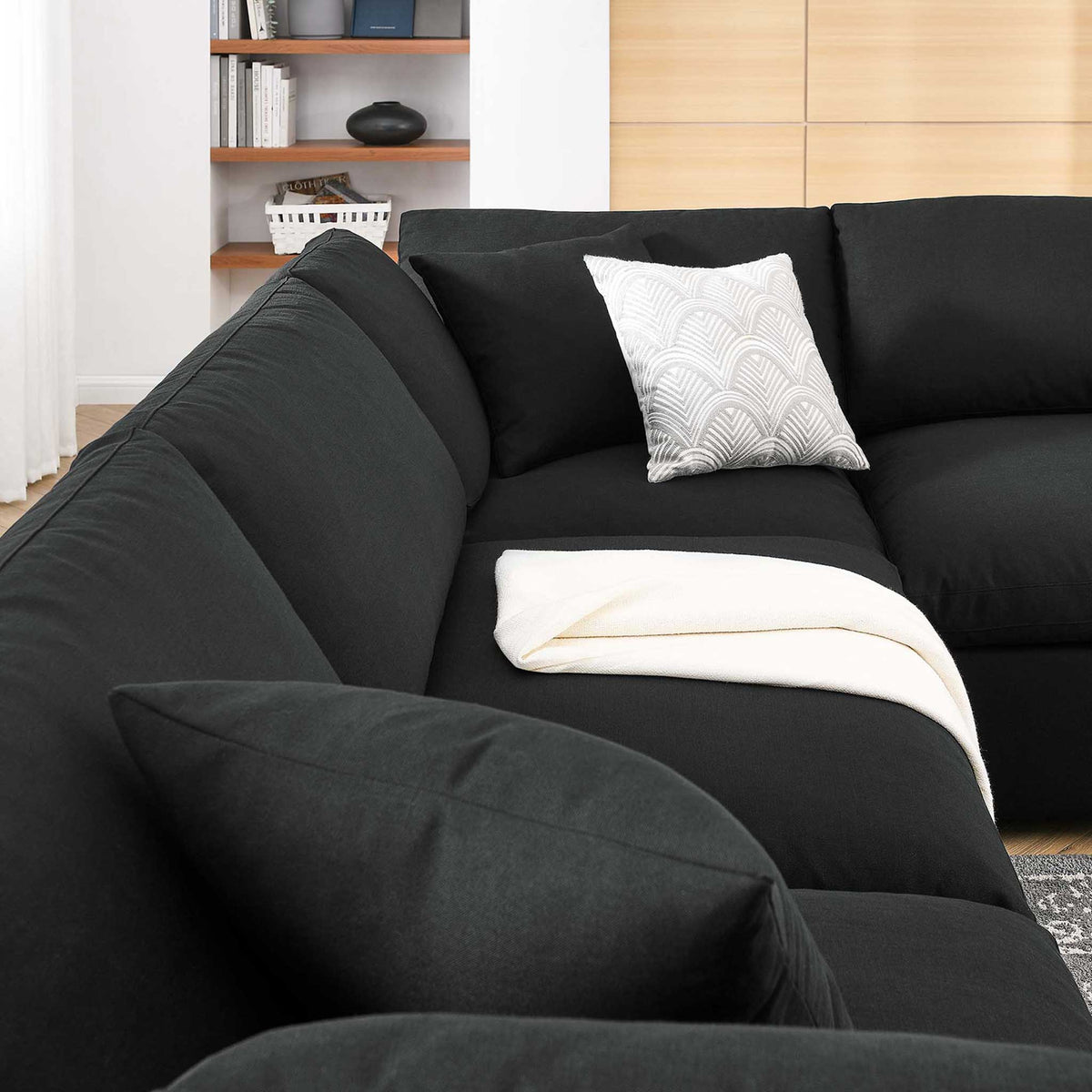 Lofty black back pillows and broad seat cushions create plush comfort along the sectional.