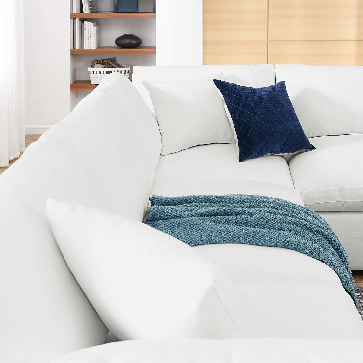 Plump white pillows and deep seats create an inviting spot at the sectional's corner.
