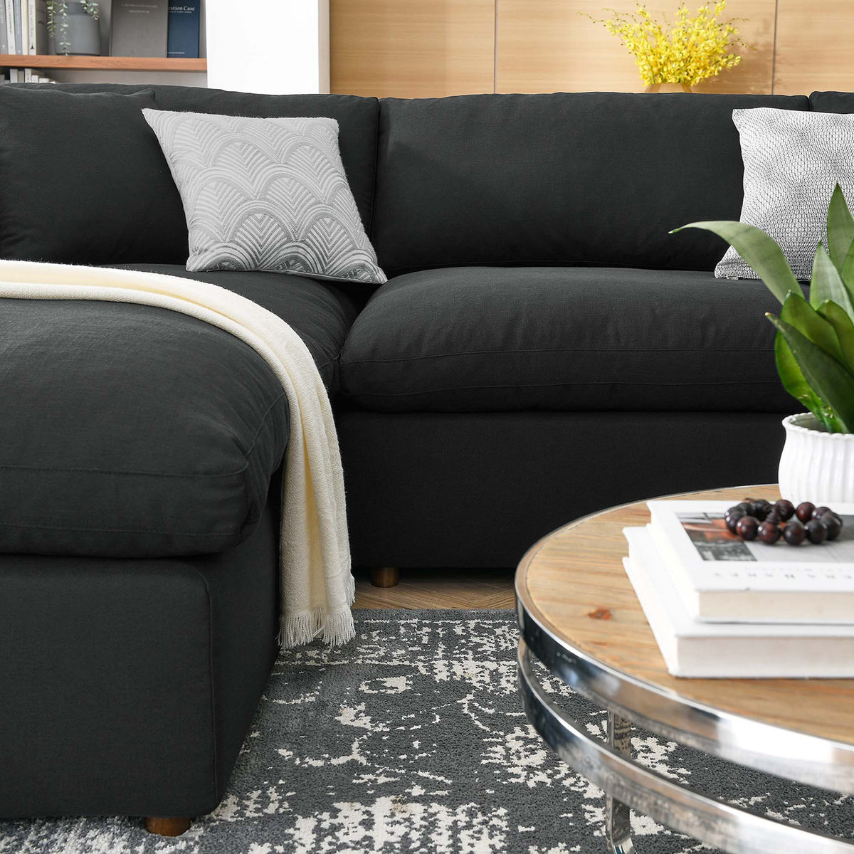 Deep black seat cushions and soft back pillows make the extended sofa easy to settle into.