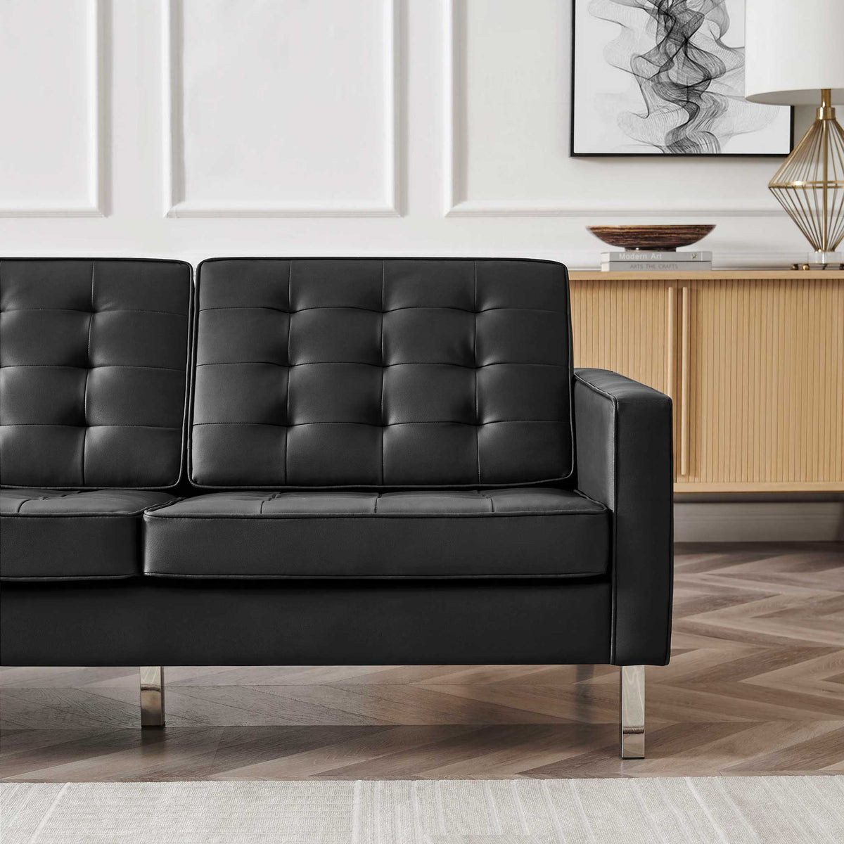 Plush black biscuit-tufted cushions and a clean-lined arm create an inviting place to sit.