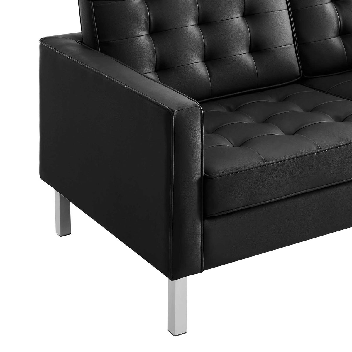 Supple black vegan leather, deep cushion tufting, and crisp seams elevate the slim arm design.
