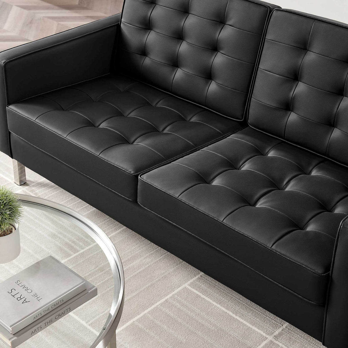 Deep biscuit tufting adds inviting texture to the black vegan leather seat and back cushions.