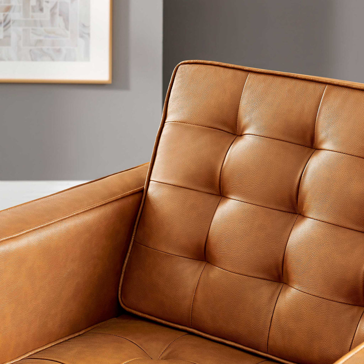 Tan vegan leather and soft biscuit tufting create a warm, textured seat and back.