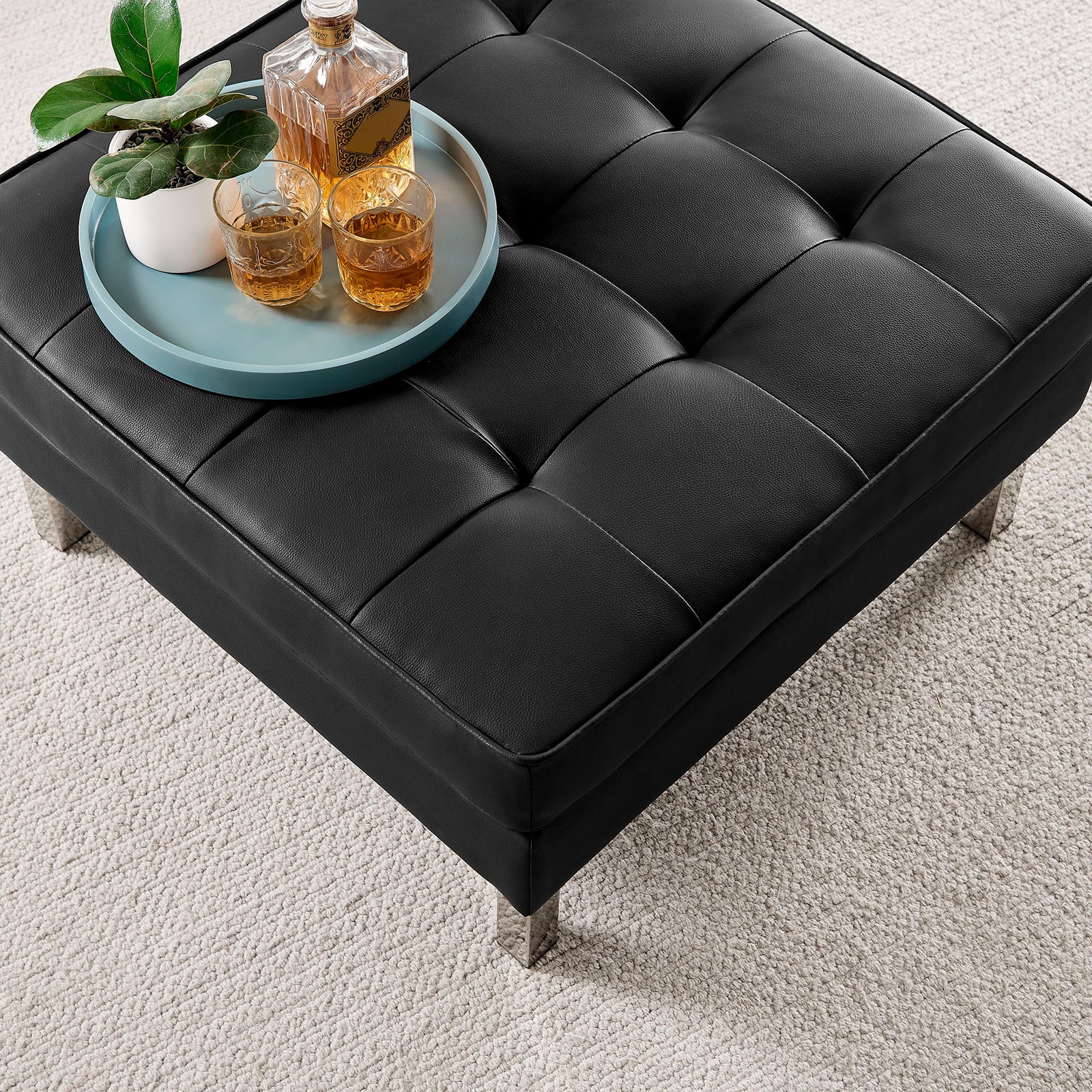 Tufted black ottoman styled with tray, drinks, and plant on soft neutral rug || EEI-3394-SLV-BLK || detail_room