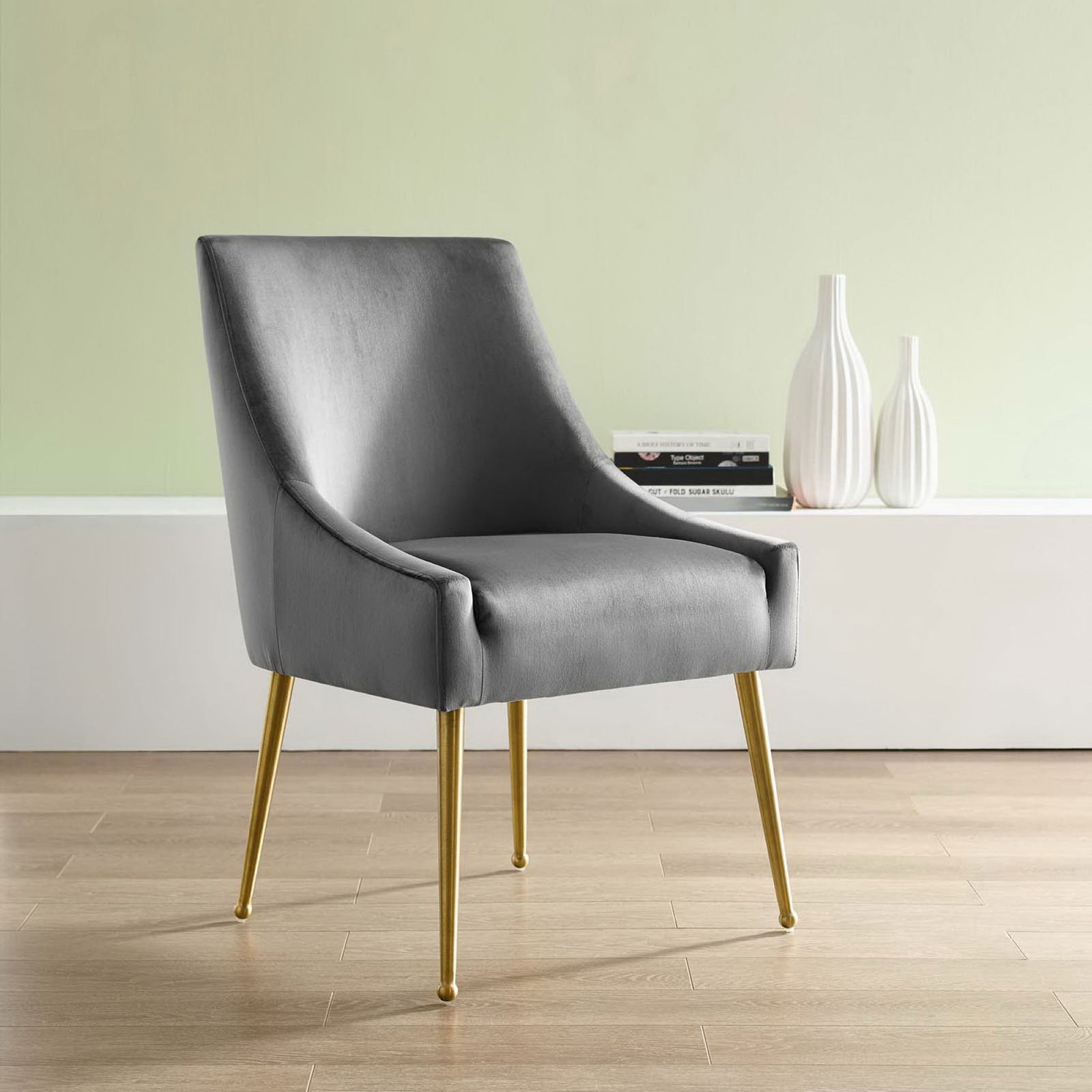 Gray velvet dining chair with gold legs styled in a modern room beside white ceramic vases. || EEI-3508-GRY || front_angle_room